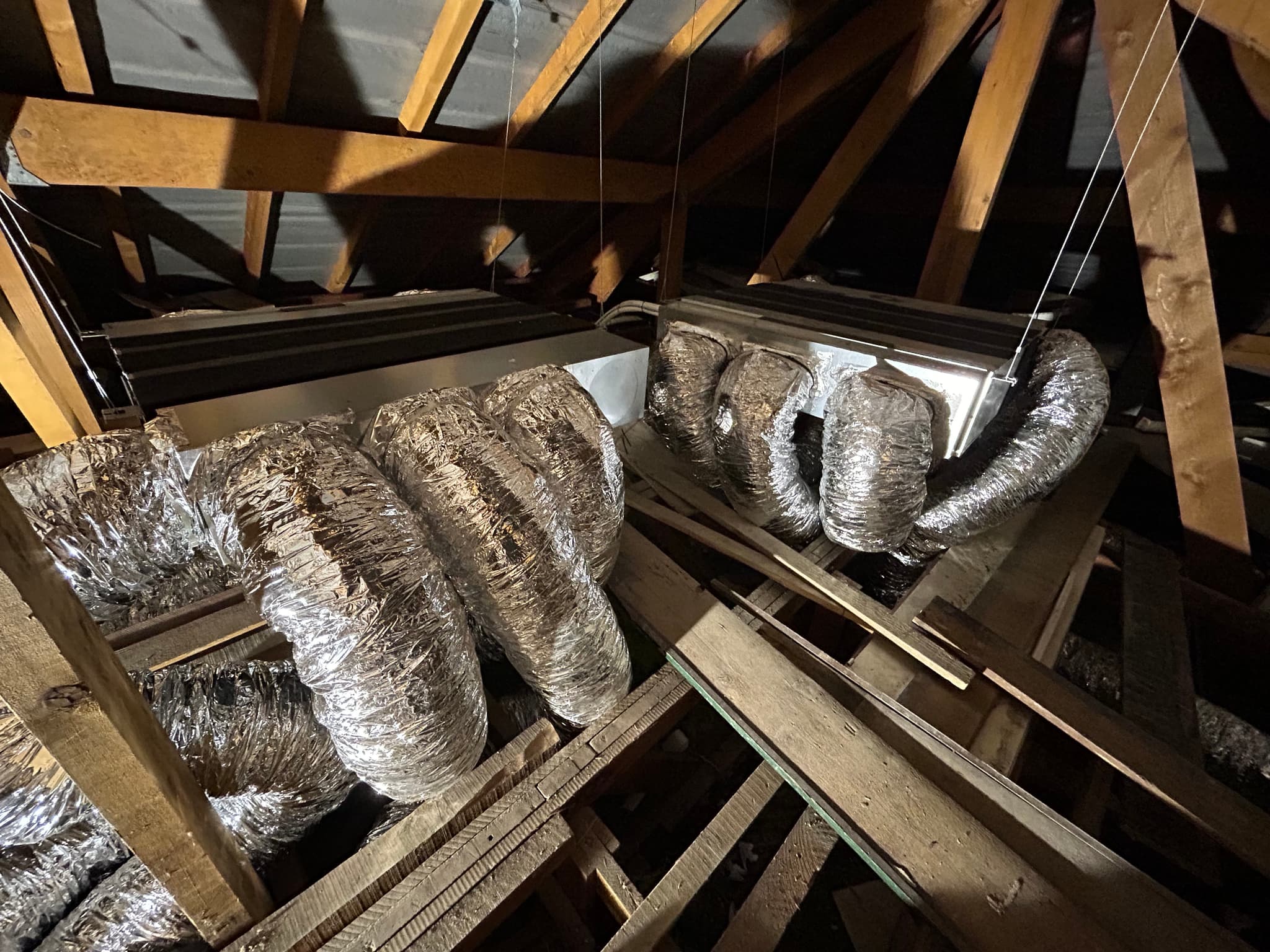 Réseau de gaines isolées raccordé au caisson de distribution, combles d'une maison à Gap