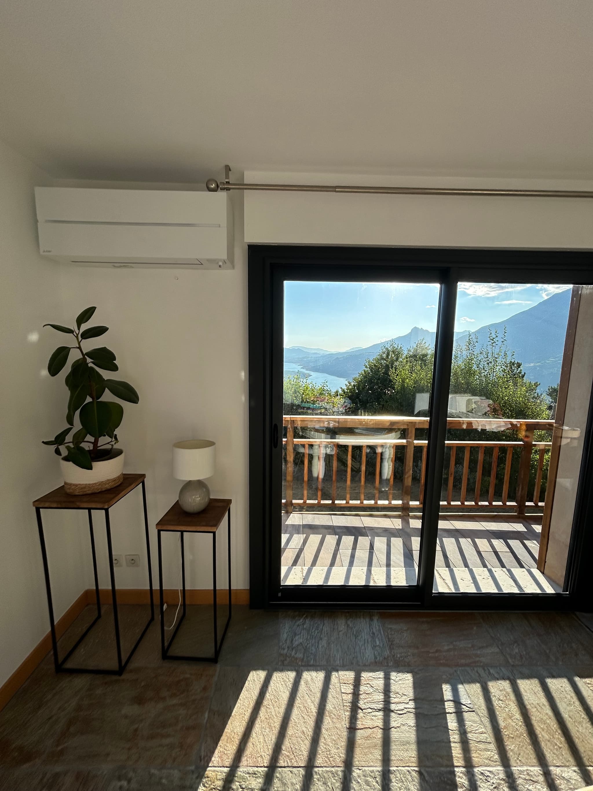 Unité murale installée au-dessus d'une baie vitrée d'un chalet à Saint-Sauveur, vue sur les montagnes de l'Embrunais