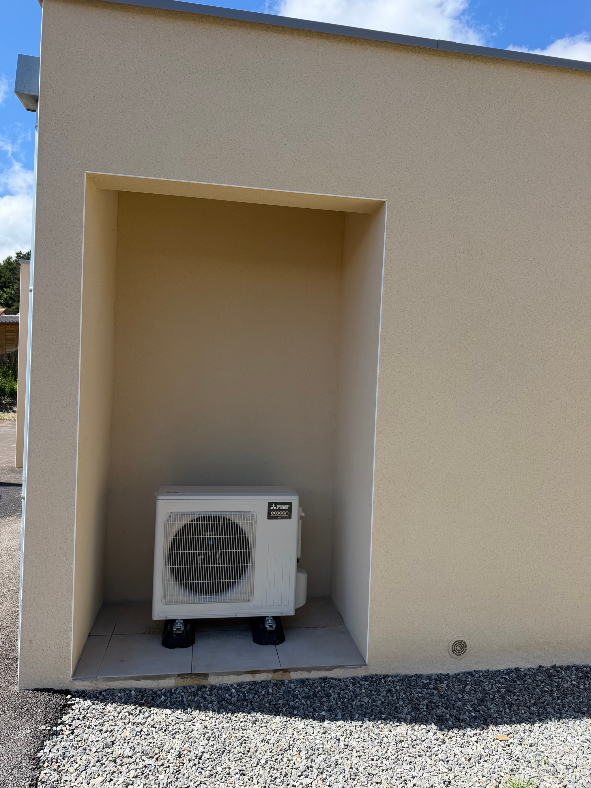 Unité extérieure de la pompe à chaleur air/eau dans le renfoncement de la façade, maison du Champsaur