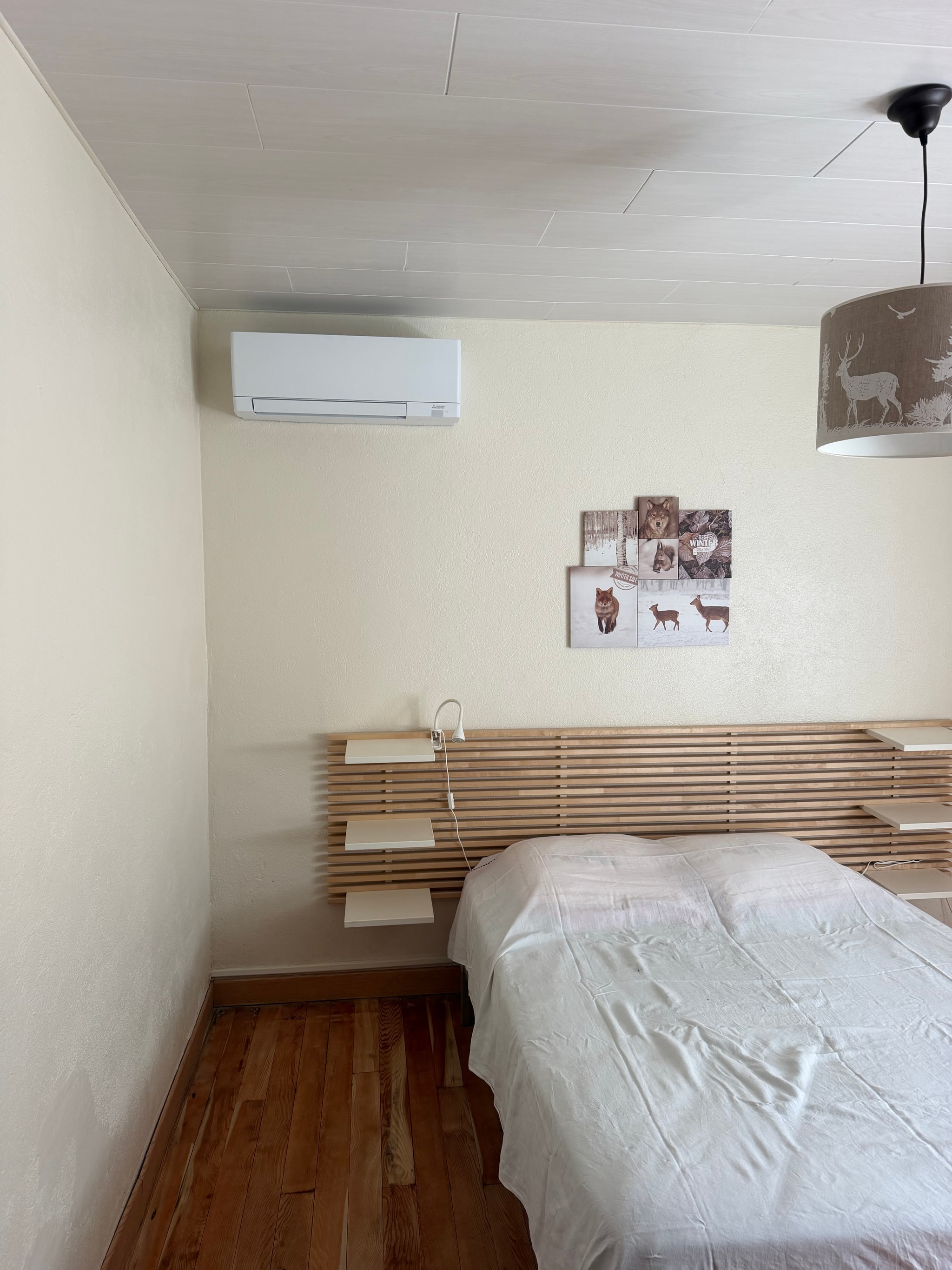Console posée au pied du mur dans la chambre à la tête de lit en tasseaux, maison à Crots