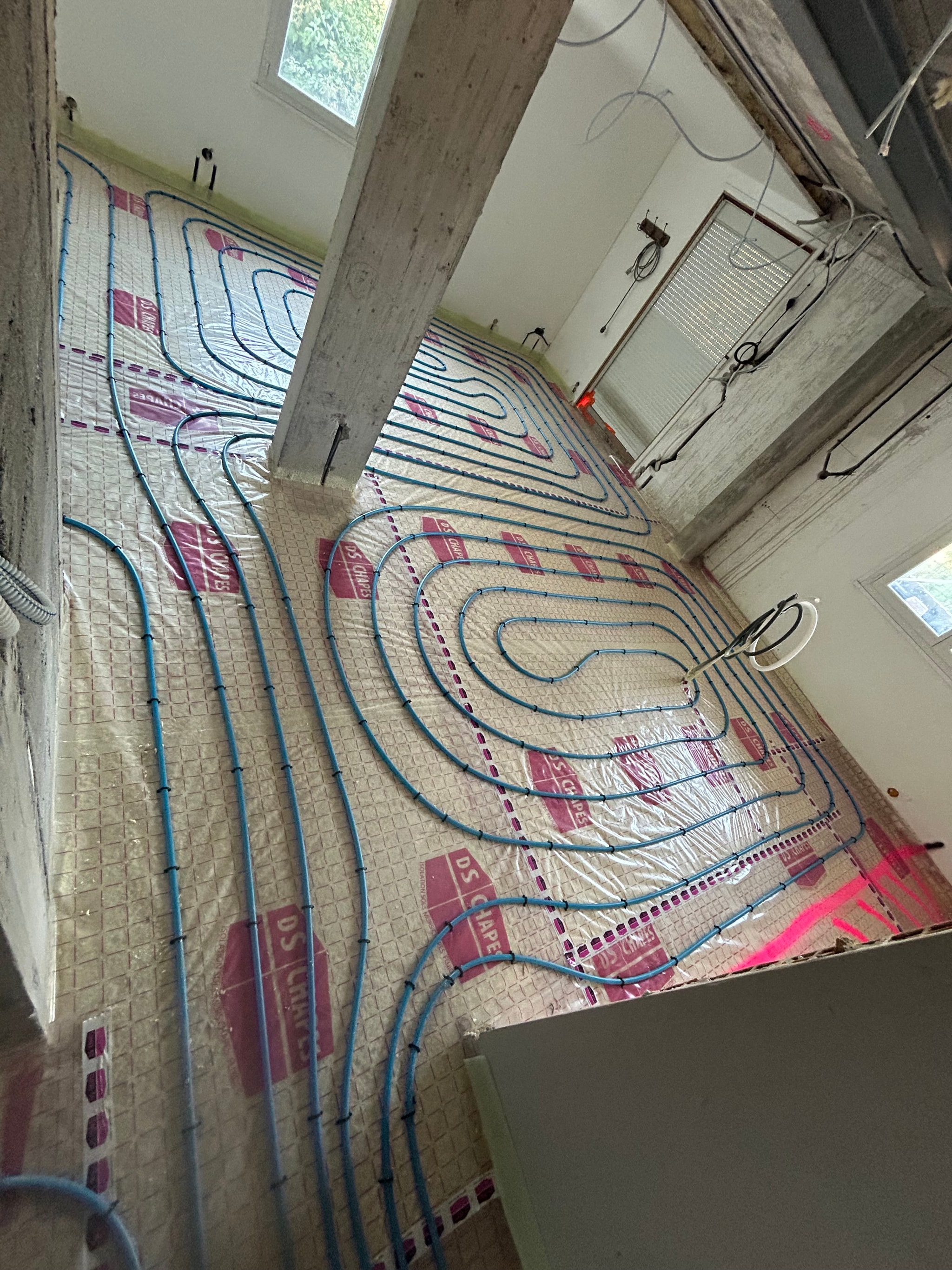 Boucles de plancher chauffant posées d'une pièce à l'autre avant la chape, maison à Embrun
