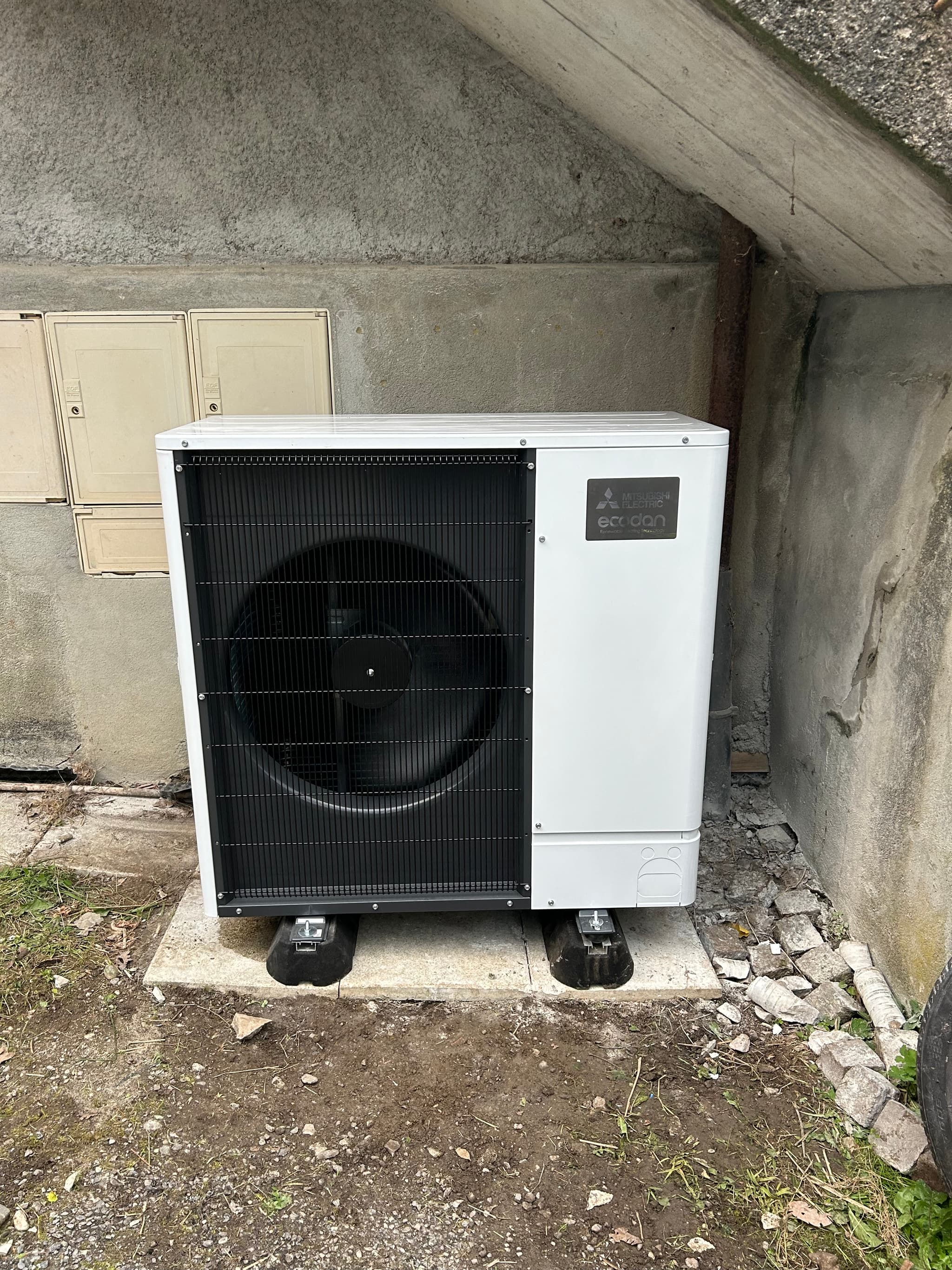 Pompe à chaleur air/eau monobloc posée au pied du mur, raccordement calorifugé, maison à Guillestre